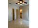 Neutral bedroom with a tiled floor, ceiling fan, and access to a bathroom at 1354 Knollwood Dr, Davenport, FL 33837