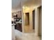 Neutral hallway leading to kitchen and bedrooms with tile flooring throughout at 1354 Knollwood Dr, Davenport, FL 33837