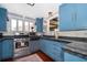 A traditional kitchen featuring light blue cabinets and stainless steel appliances at 1504 E Gore St, Orlando, FL 32806