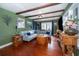 This living room features a large sectional sofa, wood beams and trim, and large windows at 1504 E Gore St, Orlando, FL 32806