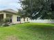 A well-maintained backyard with green grass, lush landscaping, and a mature tree for shade at 1574 Derby Glen Dr, Orlando, FL 32837