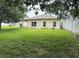 An expansive backyard featuring green grass, fencing, and the rear exterior of the home at 1574 Derby Glen Dr, Orlando, FL 32837