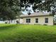 Well-maintained backyard, with lush lawn, the home features a neutral exterior and manicured landscaping at 1574 Derby Glen Dr, Orlando, FL 32837