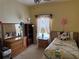 A charming bedroom with a twin bed, wooden dresser, and decorations at 1574 Derby Glen Dr, Orlando, FL 32837