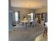 A carpeted dining room with a white table and chairs, as well as a decorative curio cabinet at 1574 Derby Glen Dr, Orlando, FL 32837