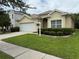 Charming single-story home featuring a two-car garage and well-manicured lawn at 1574 Derby Glen Dr, Orlando, FL 32837