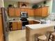 Bright eat-in kitchen featuring updated stainless steel appliances and oak cabinets at 1574 Derby Glen Dr, Orlando, FL 32837