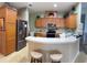 Kitchen featuring stainless steel appliances, wooden cabinets, breakfast bar, and green-painted walls at 1574 Derby Glen Dr, Orlando, FL 32837