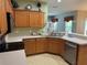 A lovely corner of the kitchen features wood cabinets and a stainless-steel dishwasher at 1574 Derby Glen Dr, Orlando, FL 32837