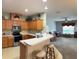 A bright kitchen featuring wooden cabinets, modern appliances, and a breakfast bar connecting to the living area at 1574 Derby Glen Dr, Orlando, FL 32837