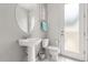 Bright bathroom featuring a pedestal sink, toilet, and a door leading to the outdoors at 1592 Carey Palm Cir, Kissimmee, FL 34747
