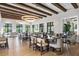 Elegant dining room featuring wood floors, tray ceiling with beams, recessed lights, and large windows at 1592 Carey Palm Cir, Kissimmee, FL 34747
