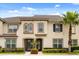 Charming townhouse with a stucco exterior, neat landscaping, and a mature palm tree at 1592 Carey Palm Cir, Kissimmee, FL 34747