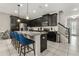 Beautiful kitchen with black cabinets, granite countertops, stainless steel appliances, and island with breakfast bar at 1592 Carey Palm Cir, Kissimmee, FL 34747