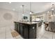 Open-concept kitchen with island seating and seamless flow to the living area and screened patio at 1592 Carey Palm Cir, Kissimmee, FL 34747