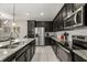 Well-equipped kitchen featuring dark cabinetry, stainless steel appliances, and granite countertops with a functional layout at 1592 Carey Palm Cir, Kissimmee, FL 34747