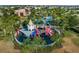 Aerial view of the fenced-in community playground with a castle turret, slides, and shaded areas for year-round enjoyment at 1592 Carey Palm Cir, Kissimmee, FL 34747