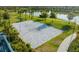 Aerial view of a pristine white sand volleyball court adjacent to a lake, perfect for recreational fun at 1592 Carey Palm Cir, Kissimmee, FL 34747