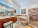 Bright bathroom featuring double vanities, jacuzzi tub, tiled walk-in shower, and tile floors at 1640 Mayfield Ave, Winter Park, FL 32789