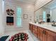 This bathroom features double sinks, a large mirror, tiled floors, patterned wallpaper, and a garden window at 1640 Mayfield Ave, Winter Park, FL 32789