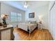Charming bedroom with hardwood floors, a white metal bed frame, shuttered windows, and an antique white dresser at 1640 Mayfield Ave, Winter Park, FL 32789