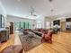 Open-concept living area with access to the backyard includes hardwood floors, fan, and view of kitchen and dining at 1640 Mayfield Ave, Winter Park, FL 32789