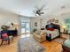 Bright main bedroom featuring hardwood floors, pool views, sitting area, and a large dark wood bed at 1640 Mayfield Ave, Winter Park, FL 32789