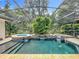 Screened in pool featuring waterfalls and mature landscaping at 1640 Mayfield Ave, Winter Park, FL 32789