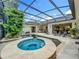 Beautiful in-ground spa and pool inside of screened-in lanai overlooking the spacious patio at 1640 Mayfield Ave, Winter Park, FL 32789