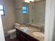Well-lit bathroom featuring a dual sink vanity with granite countertops and a mirror at 17836 Palm St, Umatilla, FL 32784