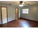 Comfortable bedroom with ceiling fan, window, wood-look flooring, and easy bathroom access at 17836 Palm St, Umatilla, FL 32784