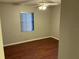 Cozy bedroom featuring wood floors, a modern ceiling fan, and a window for natural light at 17836 Palm St, Umatilla, FL 32784
