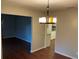 View of the dining room leading to the kitchen, with modern lighting and neutral paint at 17836 Palm St, Umatilla, FL 32784