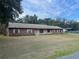 Charming single-story home with a brick exterior, lawn, and inviting curb appeal at 17836 Palm St, Umatilla, FL 32784
