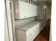 Butler pantry with counterspace, ample white cabinet storage, and hardwood flooring at 17836 Palm St, Umatilla, FL 32784