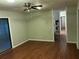Open living room with wood floors, ceiling fan, and access to the kitchen and patio at 17836 Palm St, Umatilla, FL 32784