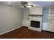 Cozy living room with hardwood floors, brick fireplace, and built-in shelving at 17836 Palm St, Umatilla, FL 32784