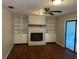Inviting living room with a white brick fireplace, built-in shelving, ceiling fan and wood-look flooring at 17836 Palm St, Umatilla, FL 32784