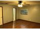 Bedroom with neutral walls, ceiling fan, wood floors, and window overlooking the yard at 17836 Palm St, Umatilla, FL 32784