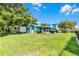 Large grassy yard with mature trees, a patio area, and a canal view at 1811 Missouri Ave, Sanford, FL 32771