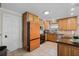 An eat-in kitchen features an orange refrigerator, tile floors and stainless steel dishwasher at 1811 Missouri Ave, Sanford, FL 32771