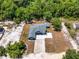 An aerial view of a blue single-story home with a gray roof situated on a spacious lot with mature trees at 1845 Springhead Dr, Deltona, FL 32725