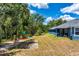 Spacious backyard features green grass, playground, and wooded area at 1845 Springhead Dr, Deltona, FL 32725
