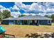 The backyard has a large green lawn, a playground, and an outdoor seating area on the covered patio at 1845 Springhead Dr, Deltona, FL 32725
