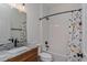 Bathroom features granite countertop, wood cabinets, shower and tub combination, and dinosaur shower curtain at 1845 Springhead Dr, Deltona, FL 32725