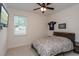 Bedroom features neutral walls, carpet, ceiling fan, television, and Patriots jersey at 1845 Springhead Dr, Deltona, FL 32725