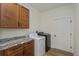 Laundry room features washer, dryer, granite countertop, and wood cabinets at 1845 Springhead Dr, Deltona, FL 32725