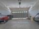Spacious garage with concrete flooring, overhead storage racks, and an insulated garage door at 204 Birkdale St, Davenport, FL 33897