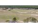 An aerial view captures the expansive golf course and the rear of nearby homes, all set against a backdrop of trees at 204 Birkdale St, Davenport, FL 33897