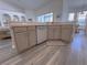 Kitchen island with a dishwasher, light wood cabinets, and an undermount sink, offering an open view of the home at 204 Birkdale St, Davenport, FL 33897